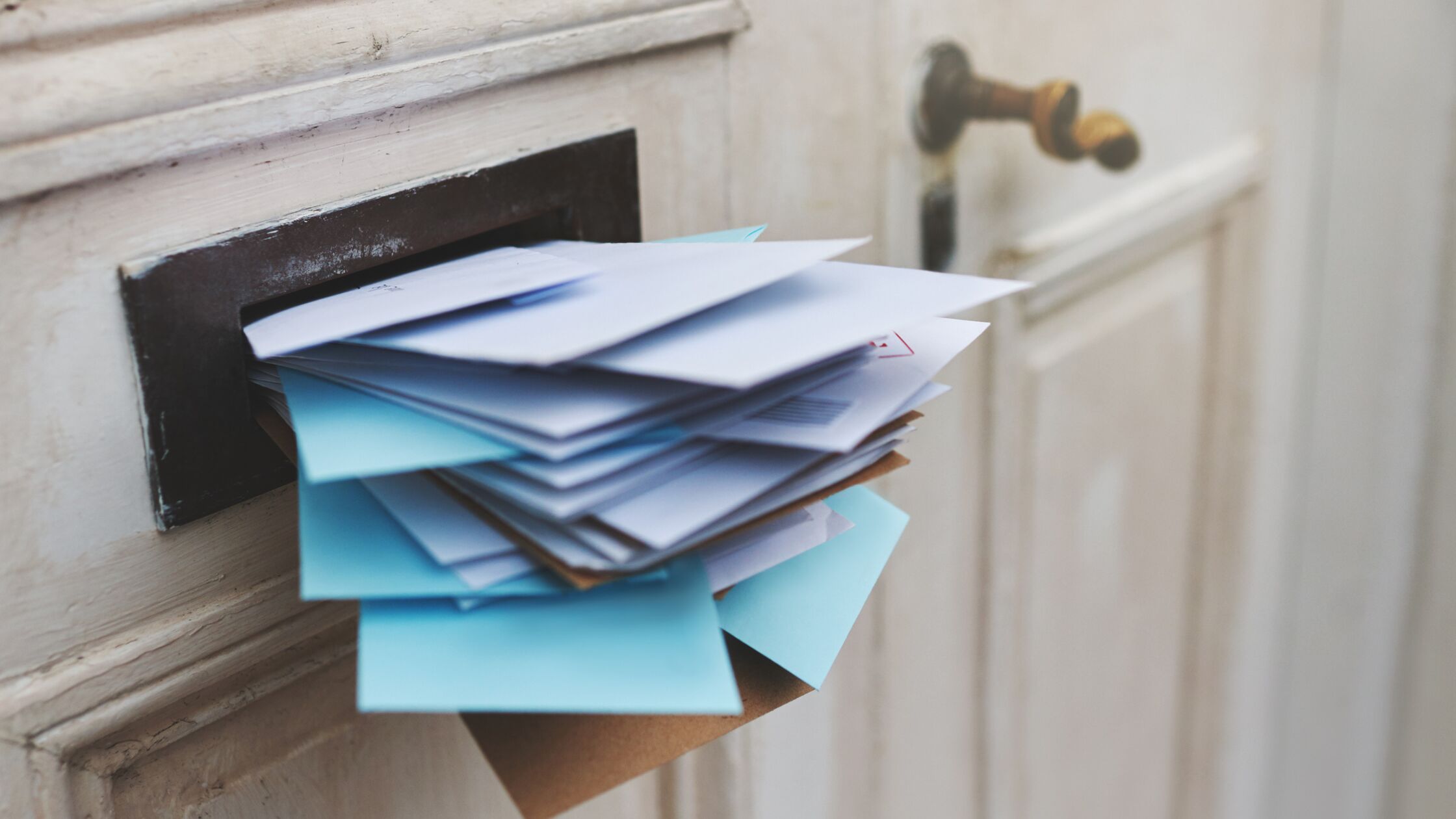Briefschlitz in einer Wohnungstür, vollgestopft mit Briefen