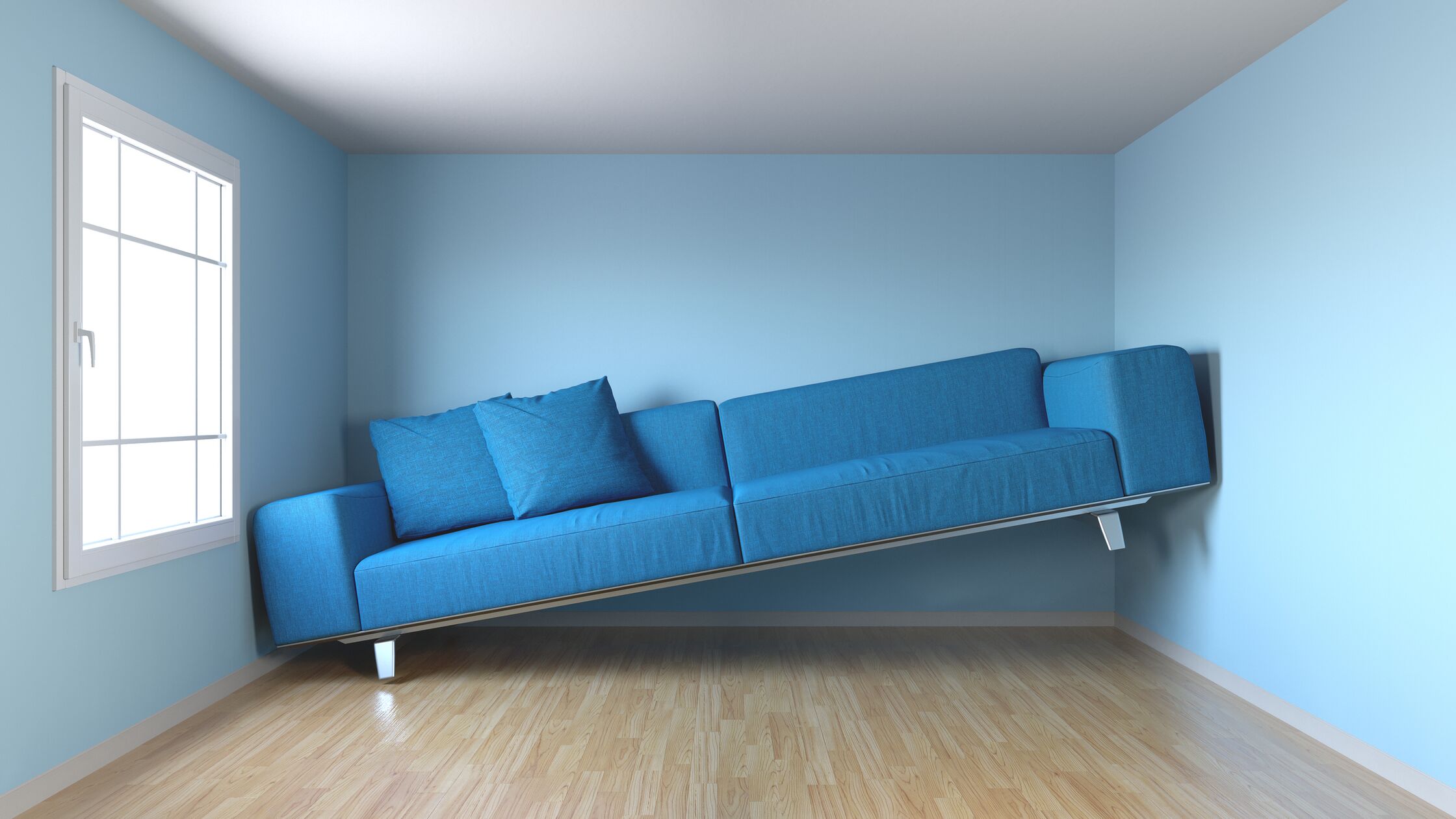 Ein blaues Sofa klemmt mit dem rechten Ende an der Wand, weil es nicht in den Raum passt