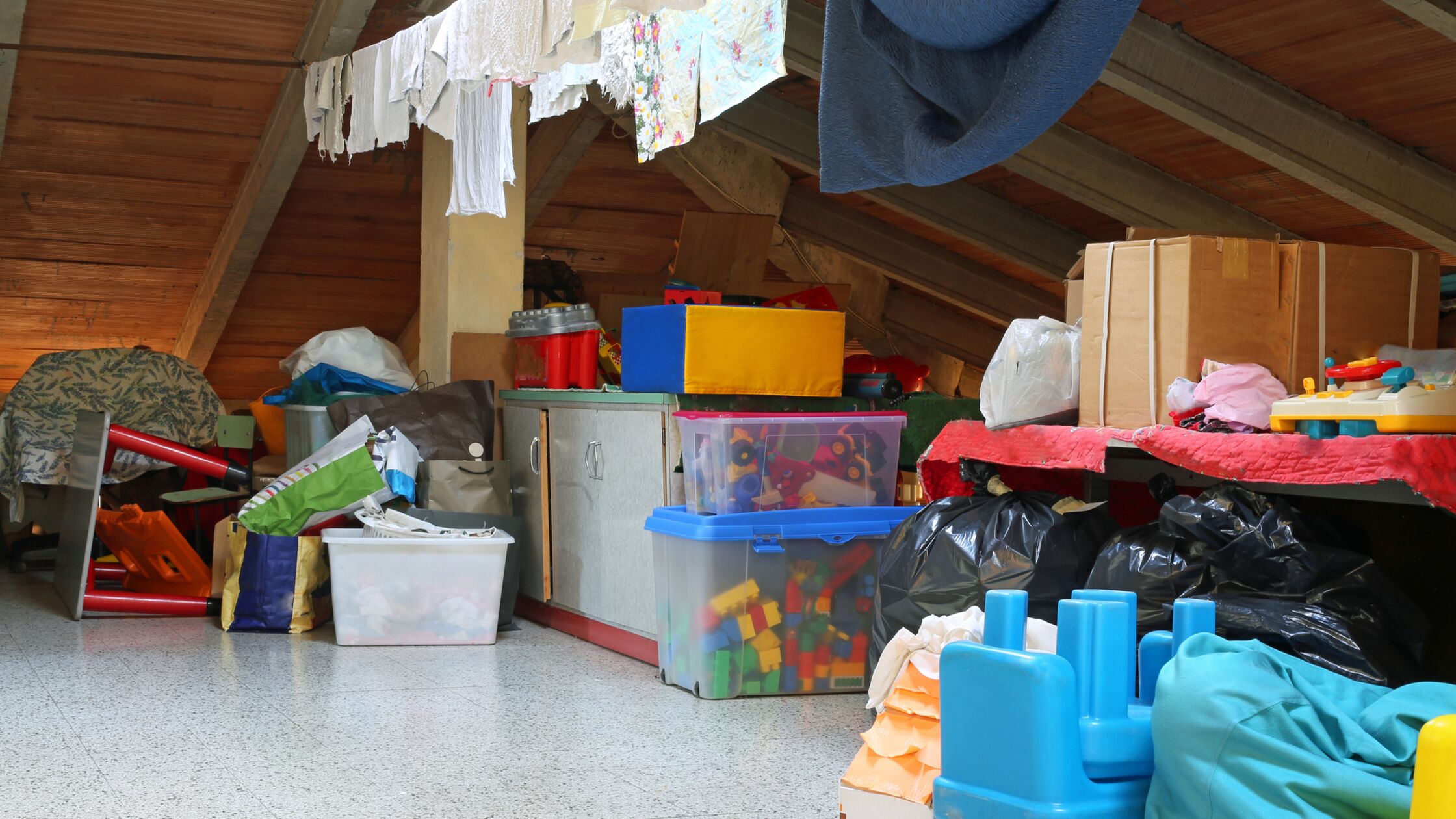 Dachboden voller Kisten mit Spielzeug und Wäscheleine