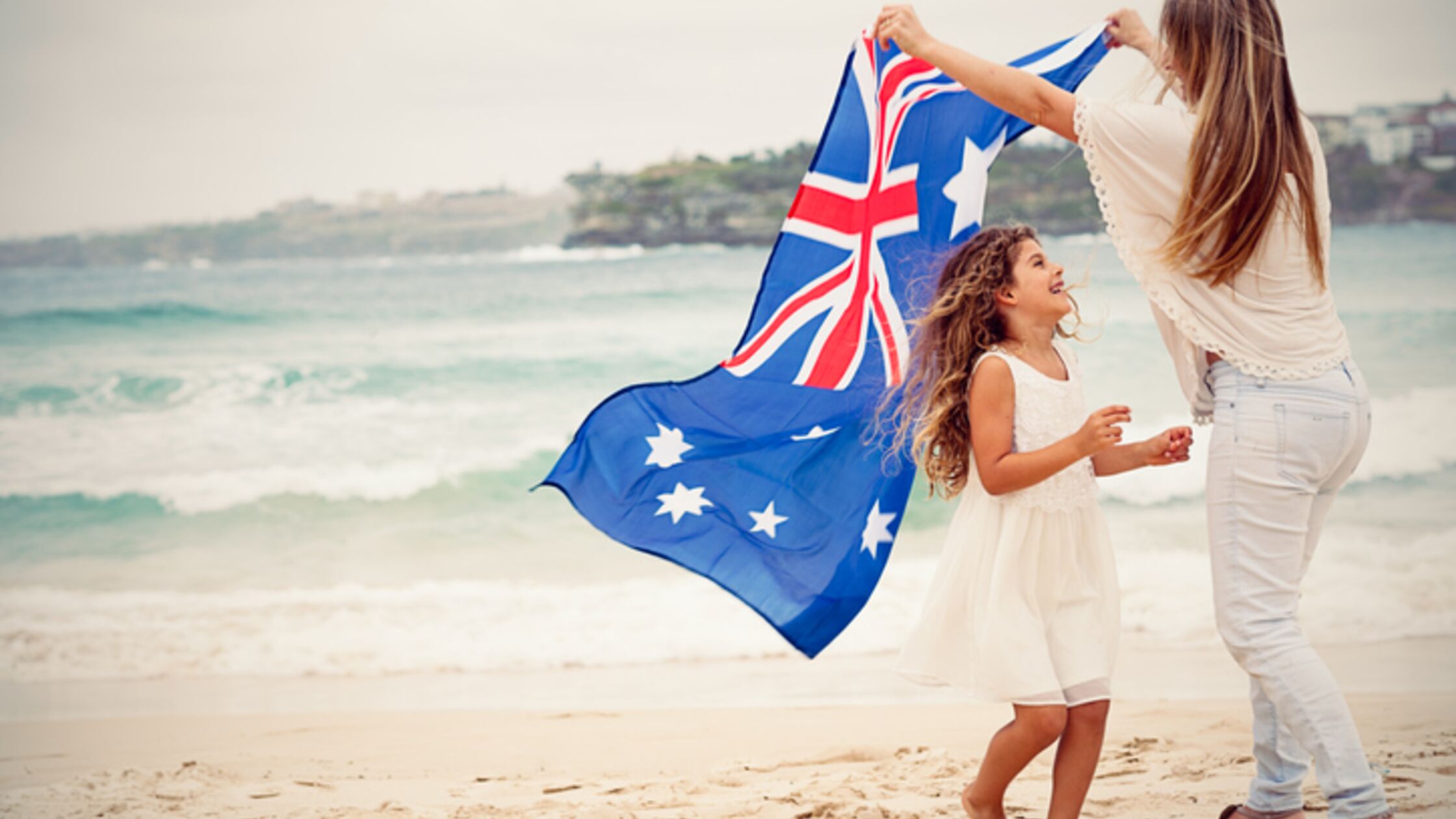 Frau und Tochter mit Australienflagge am Strand