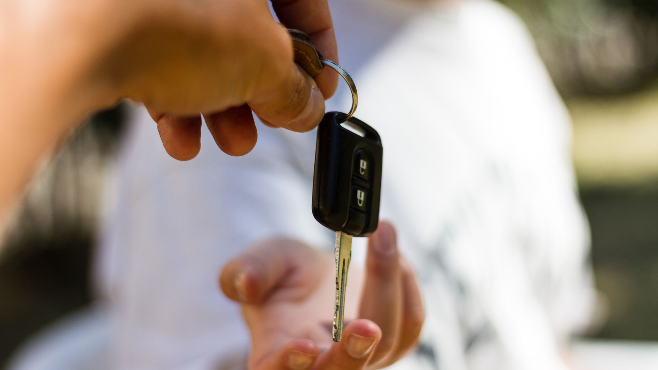 Auto verkaufen: Schnell und sicher von privat Autoschlüssel in Großaufnahme bei der Übergabe