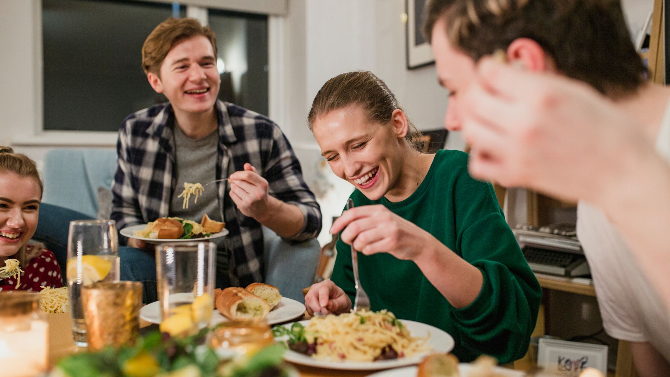 Wohnen als Student: Allein, WG, Wohnheim – was ist am besten? Lachende junge Leute kochen und essen zusammen