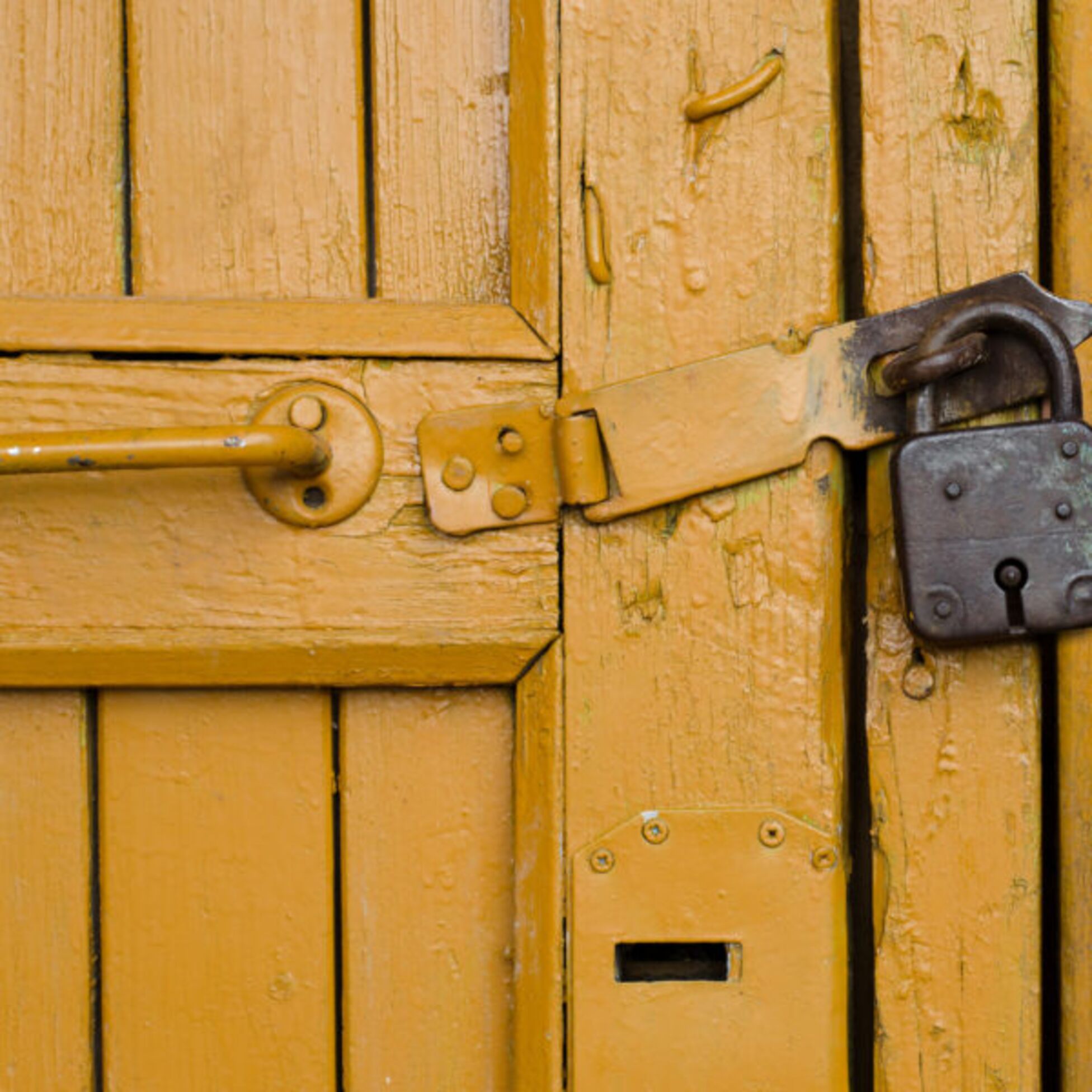 Altes Vorhägeschloss an einer alten, gelben Holztür