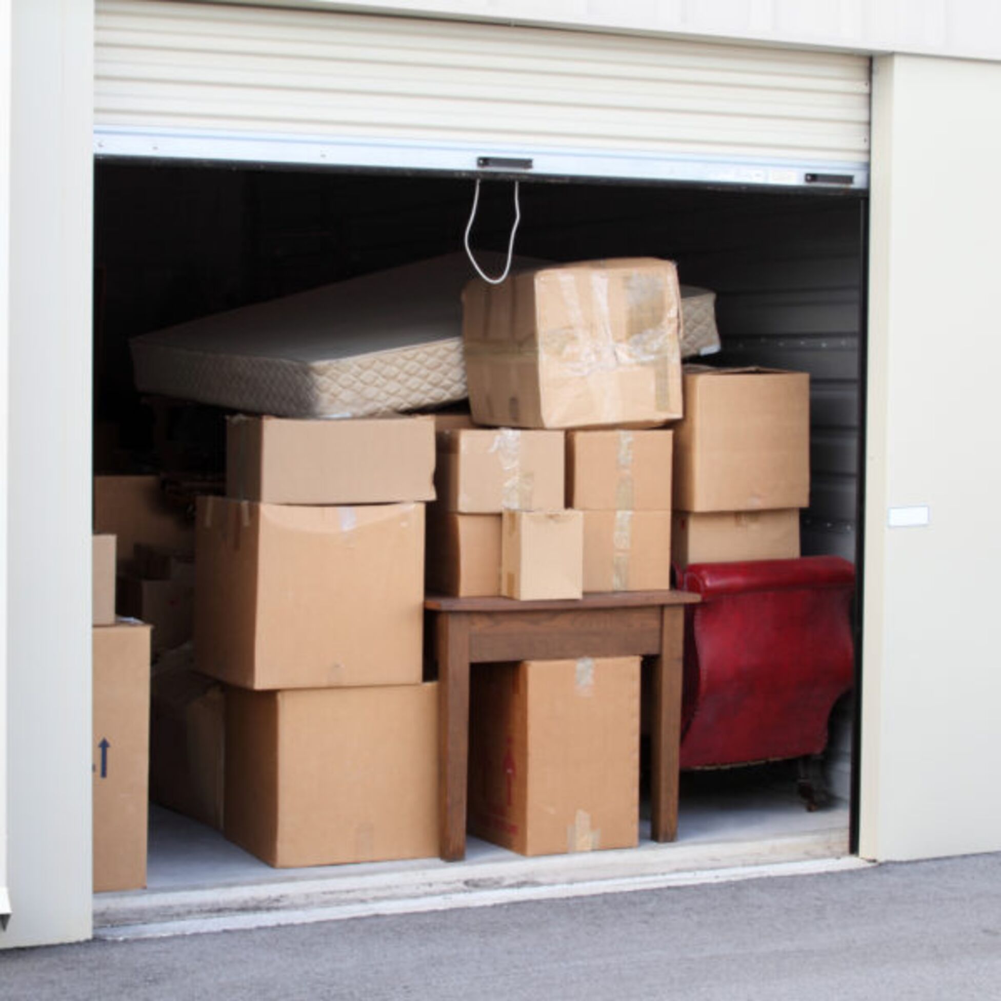 Eingelagerte Möbel und Kartons stehen in einem Selfstorage-Abteil