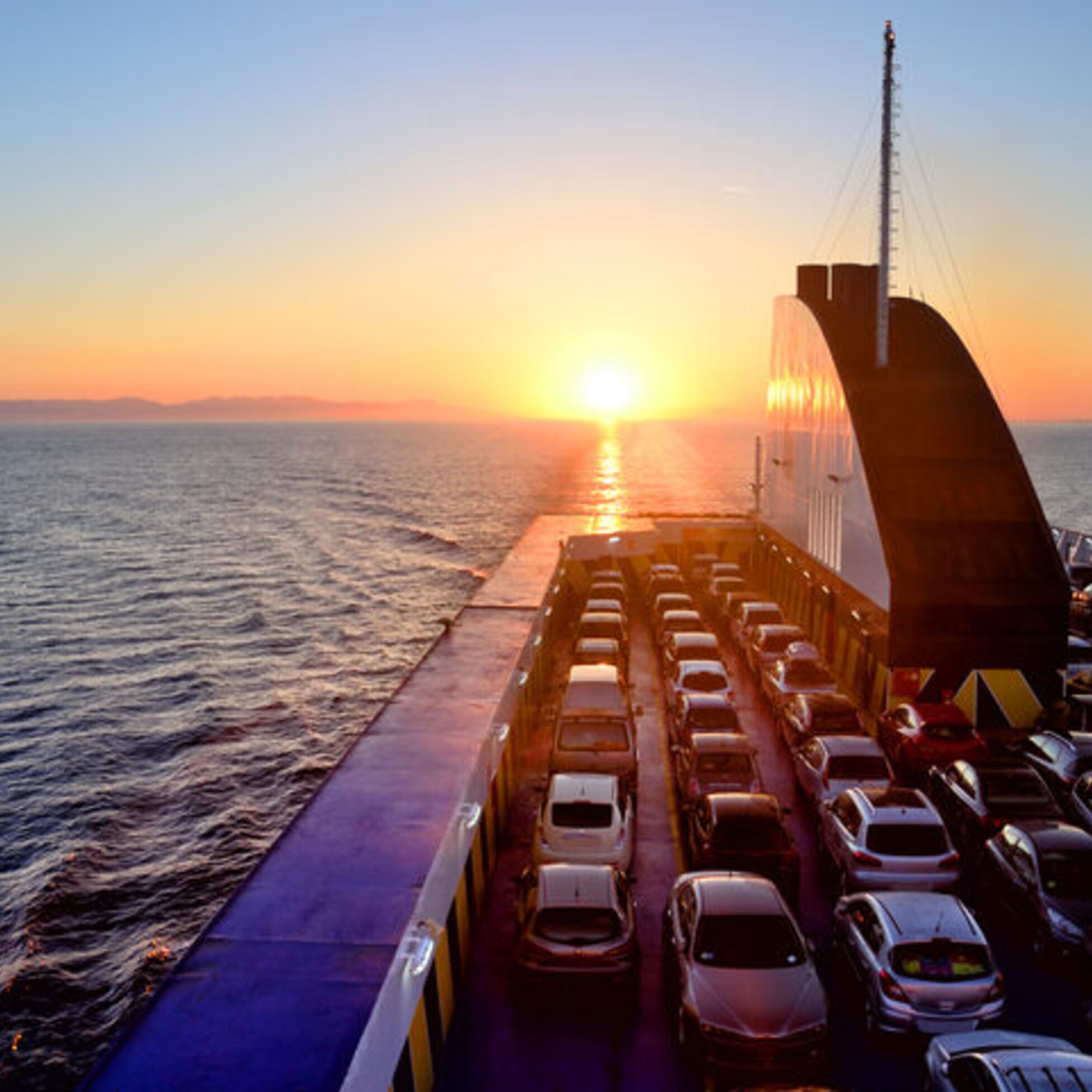 Fähre mit Autos auf See bei Sonnenuntergang