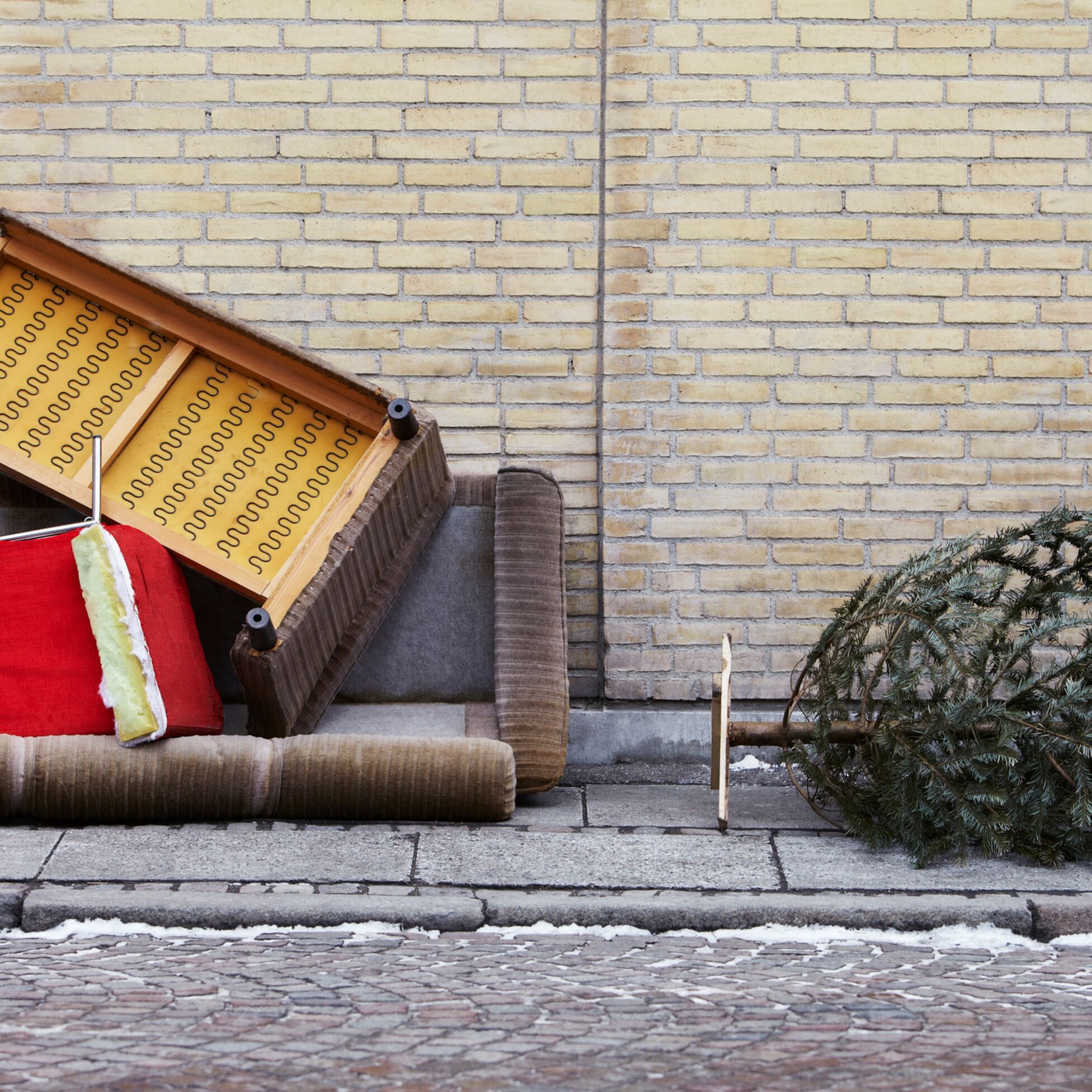 Altes Sofa und Weihnachtsbaum liegen als Sperrmüll auf der Straße