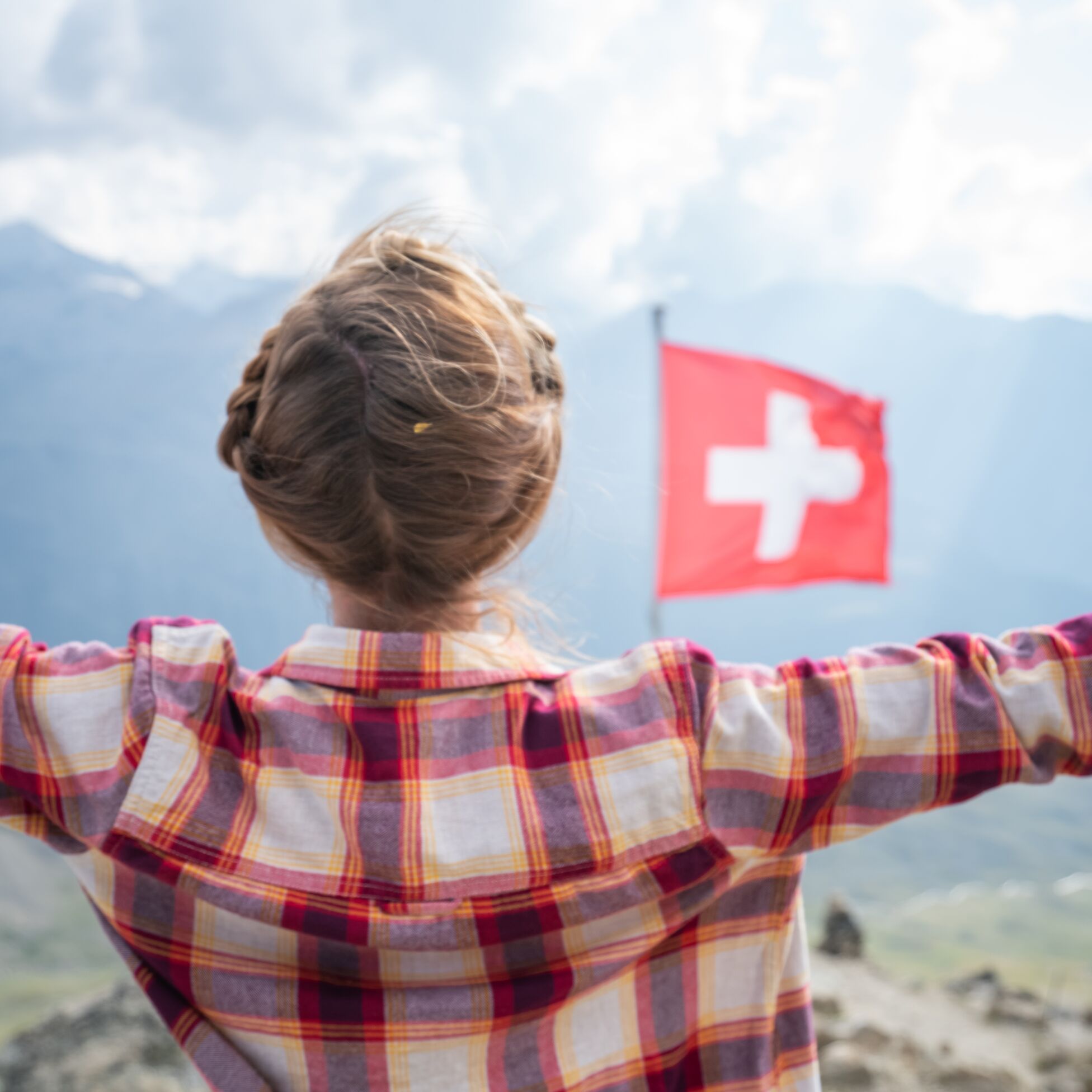 Frau am Matterhorn mit Schweizer Flagge