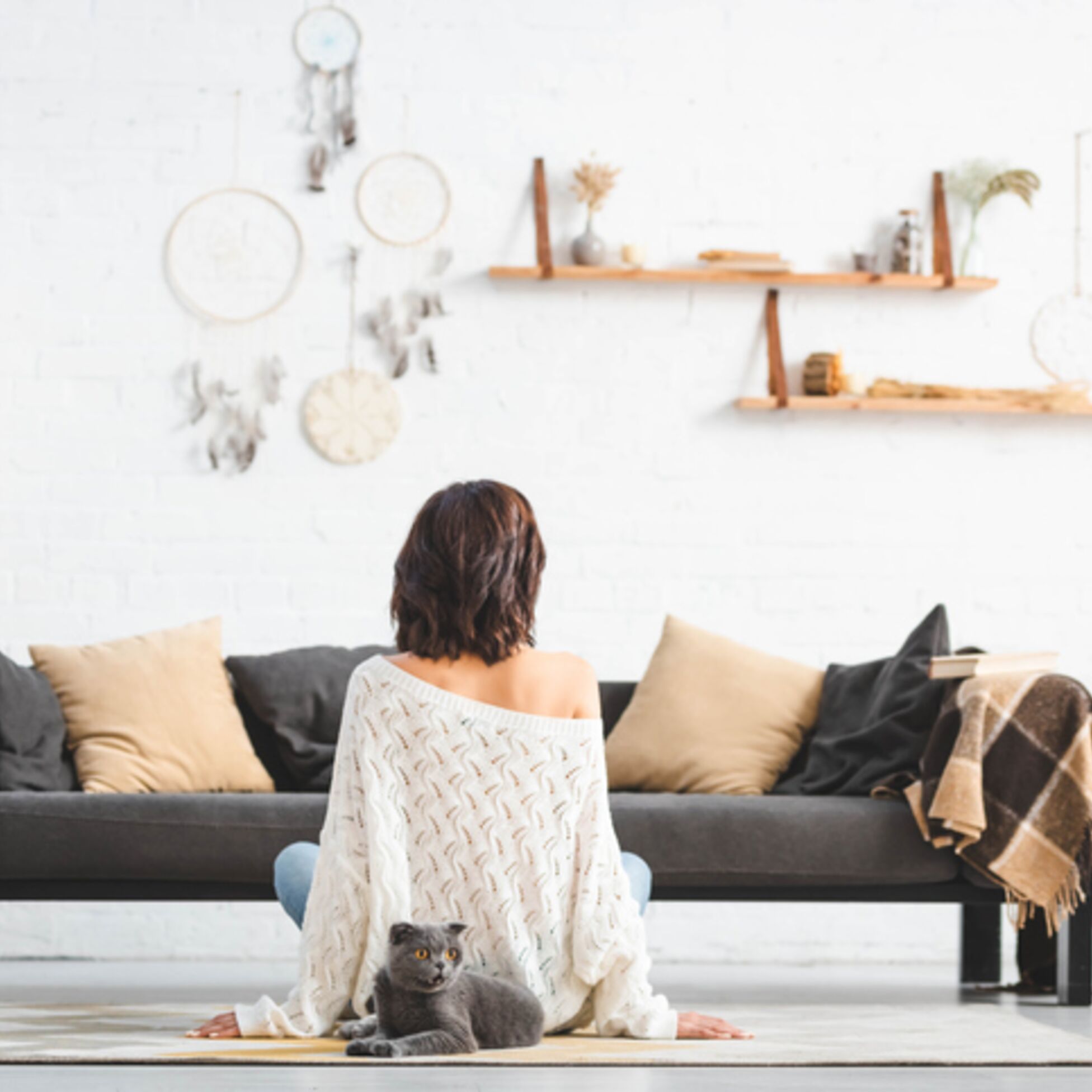 Frau sitzt in minimalistischem Wohnzimmer